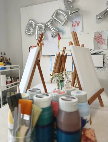 Art supplies with easels and 'BRIDE' balloons in studio.