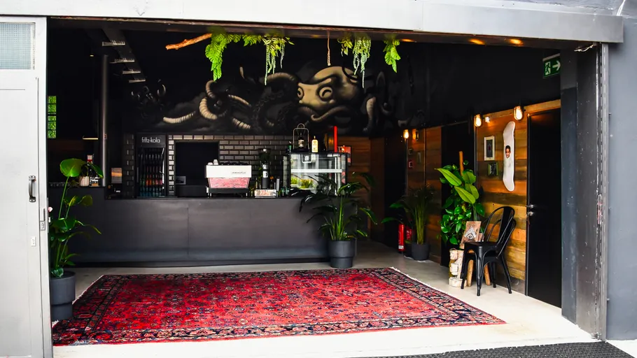 Coffee shop with plants and red carpet.