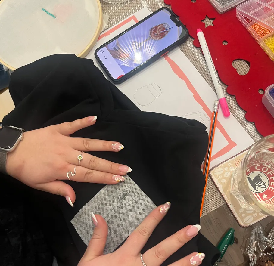 Person tracing a design with phone reference.