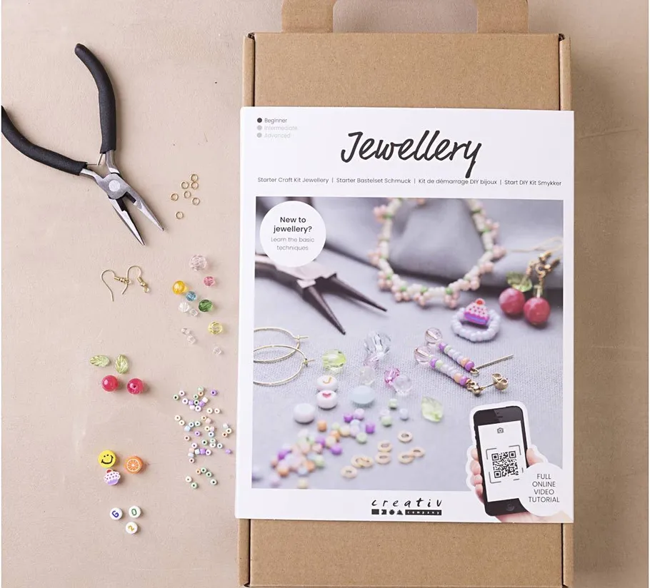 Jewelry making kit with tools and beads displayed.