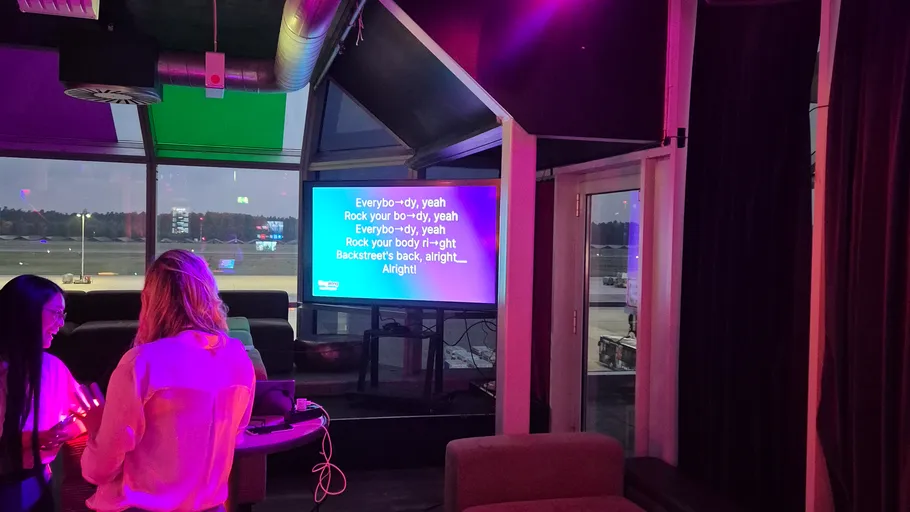 Karaoke screen displays song lyrics indoors.