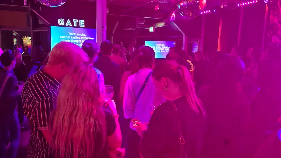 Menschen bei einem Karaoke-Event mit pinkem Licht.