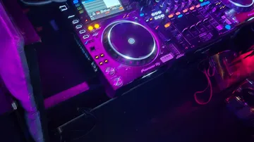 DJ-Setup mit bunten Lichtern im Nachtclub.