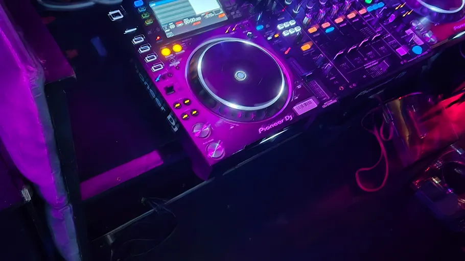 DJ setup with colorful lights in nightclub.
