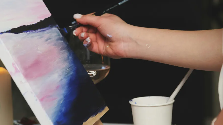 Hand painting colorful canvas, dark background.