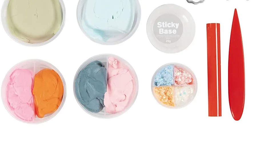 Bunte Ton-Kits mit Werkzeugen auf weißem Hintergrund.