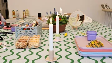 Table with crafts, candles, and snacks.