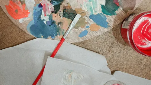 Farbpalette und Pinsel auf Holztisch