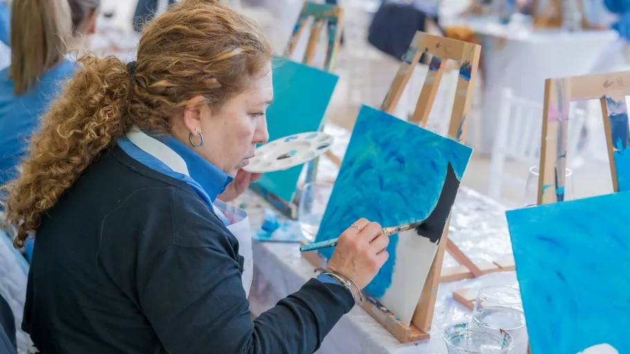 Frau malt auf Leinwand im Kunstkurs.