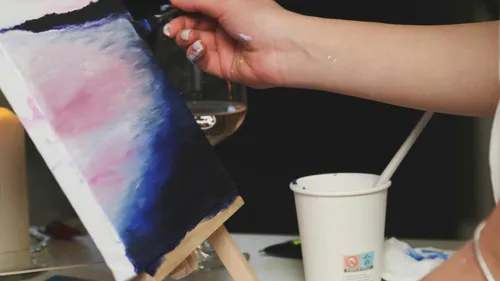 Hand painting on small canvas, indoor setting.