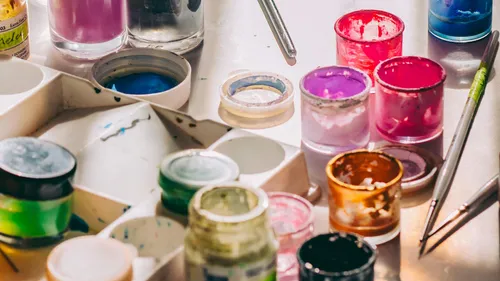 Colorful paint jars on a cluttered table.
