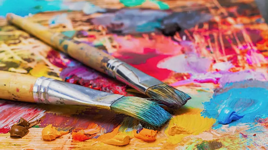 Paintbrushes resting on a colorful palette.