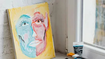 Abstraktes Gesichtsgemälde nahe Fenster mit Farben.