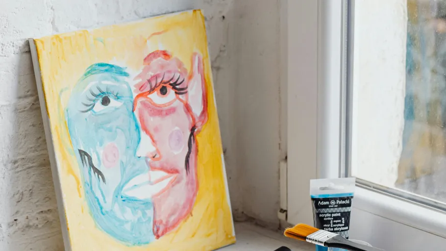 Abstract face painting near window with paints.