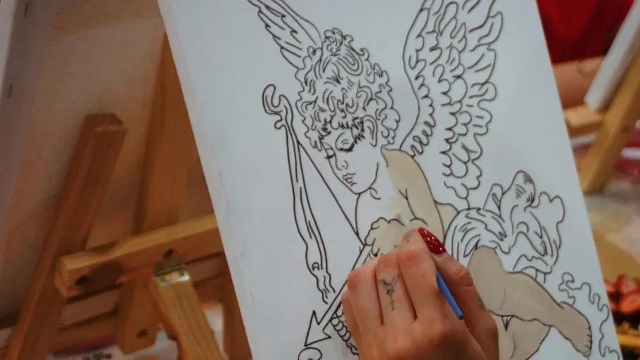 Hand painting cherub on canvas with easel.