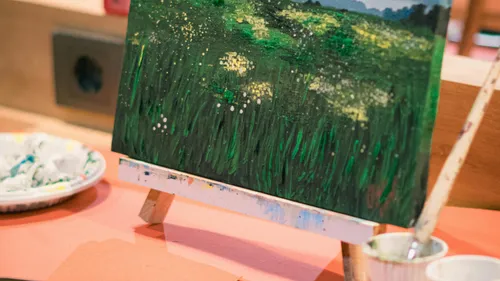Landscape painting on easel in studio.