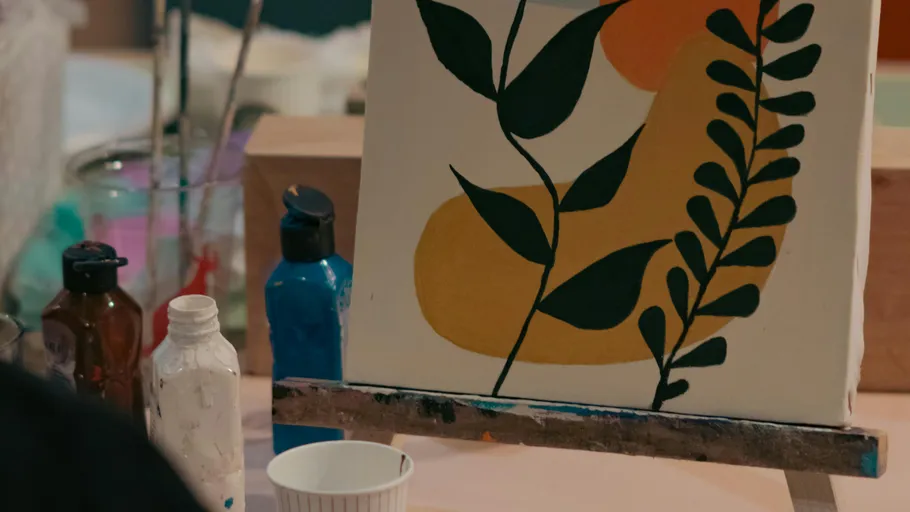 Canvas with abstract plant painting, studio setting.