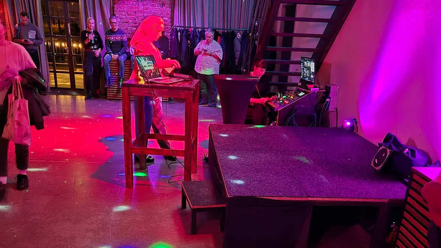DJ performing at a colorful indoor event.