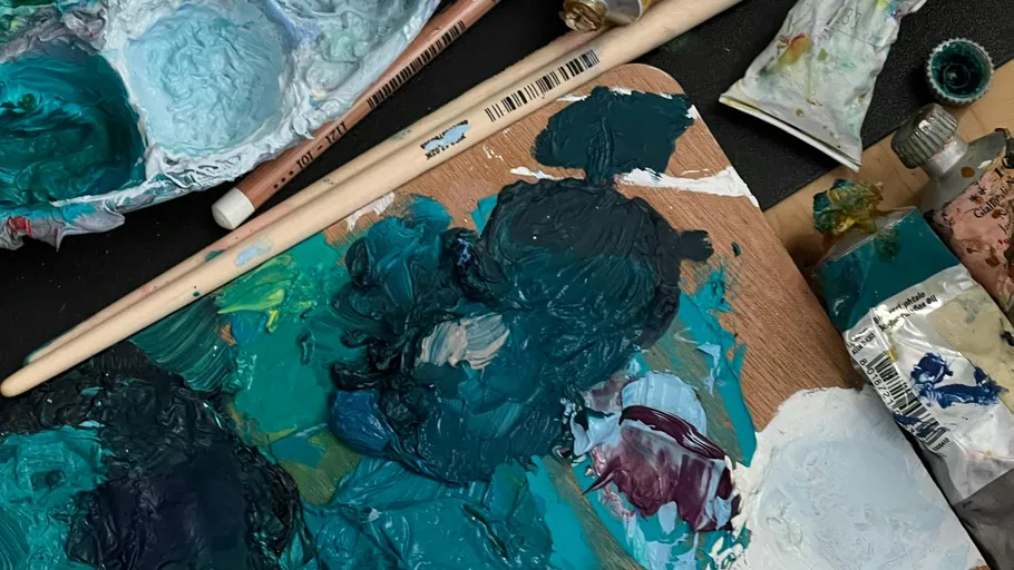 Palette mit blauer Farbe, Pinsel herum.