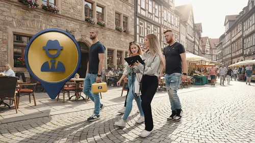 People walking on cobblestone street with a tablet.
