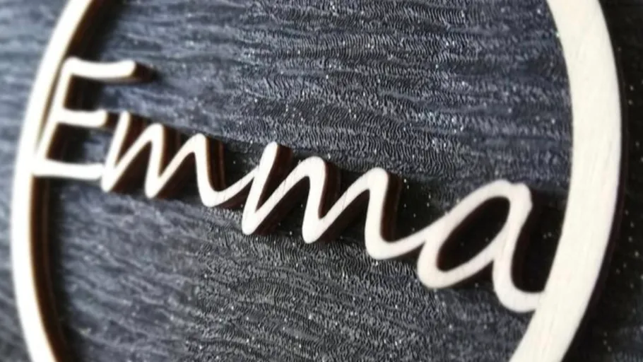 Wooden 'Emma' sign on textured surface.