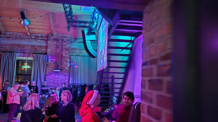 Menschen plaudern in einer rustikalen, bunten Bar.