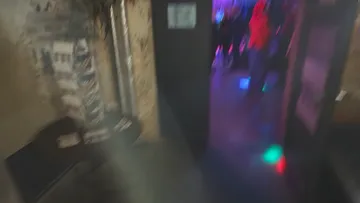 Verschwommene Clubszene mit bunten Lichtern.