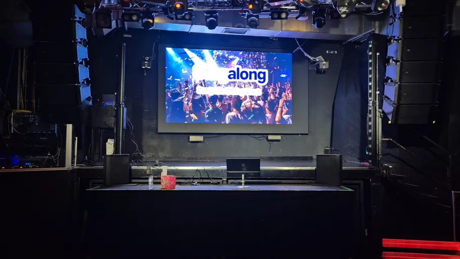 Empty stage with screen displaying 'along'.