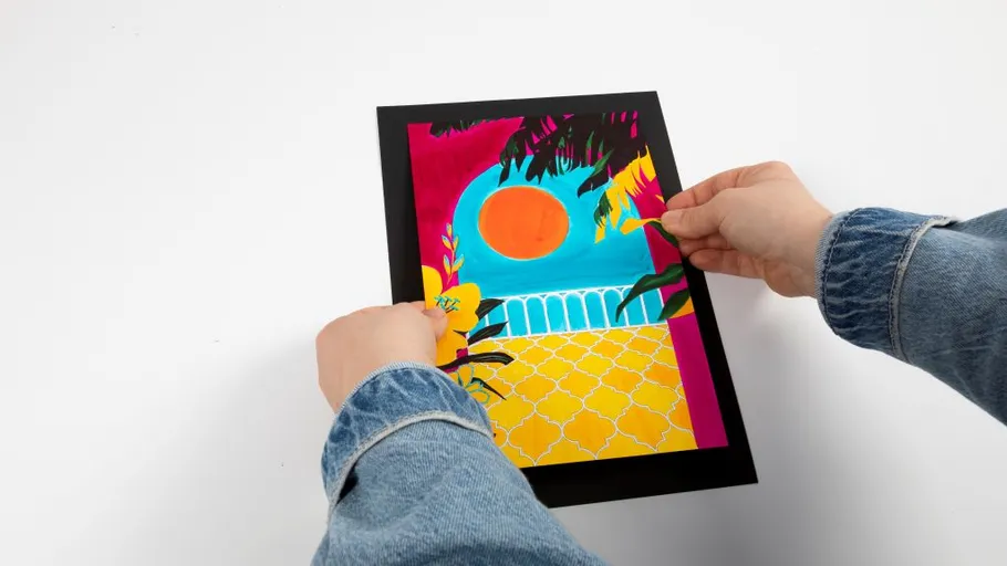 Hands holding colorful landscape artwork.