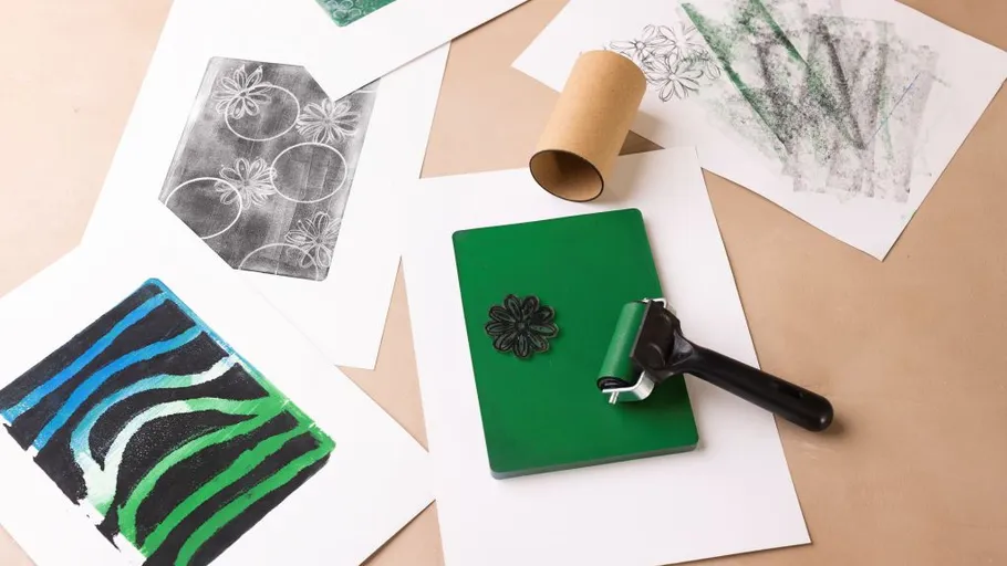 Printmaking supplies with roller and paper prints.