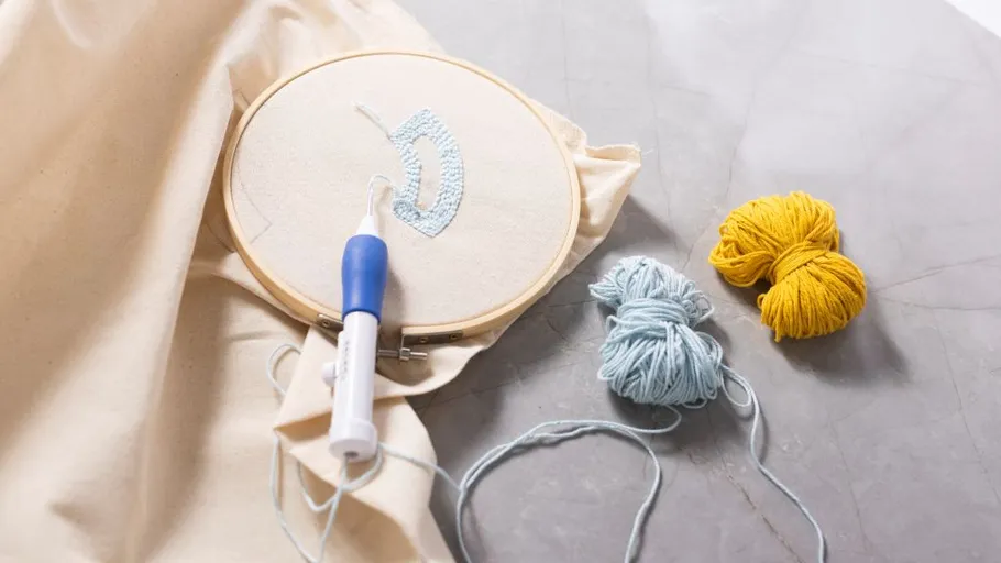 Embroidery hoop with yarn on fabric.