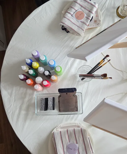 Art supplies on a table with canvas.