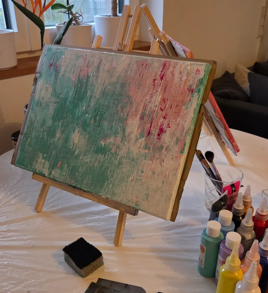 Abstraktes Gemälde auf Staffelei mit Kunstzubehör.