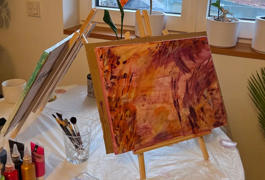 Paintings on easels in a home setting.