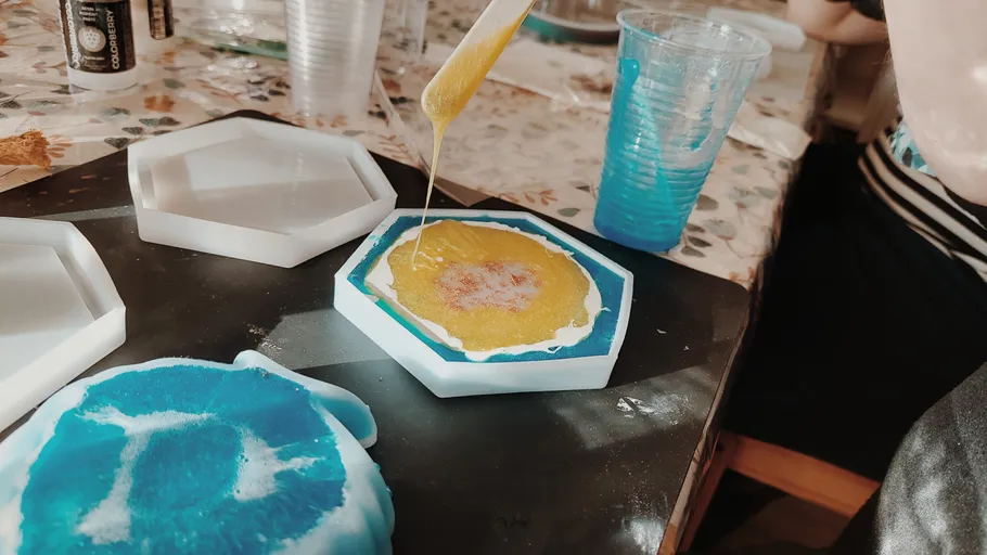 Person pours resin into hexagonal mold.
