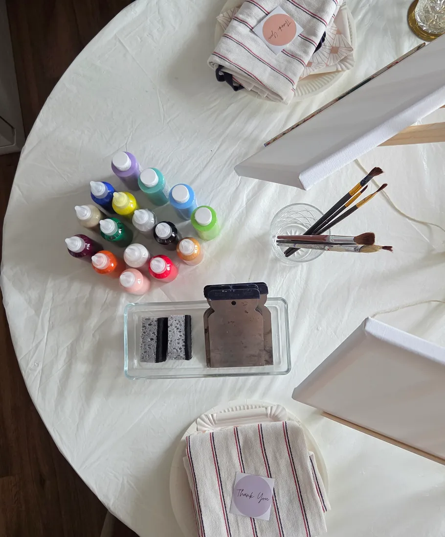 Art supplies on a table with easels.