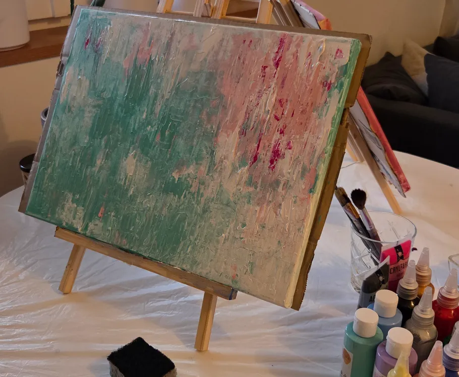 Abstraktes Gemälde auf Staffelei mit Kunstzubehör.