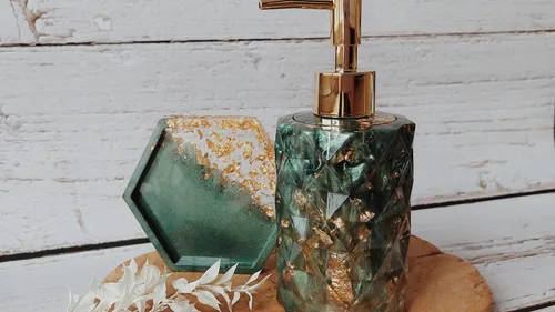 Green dispenser on wooden surface, white background.