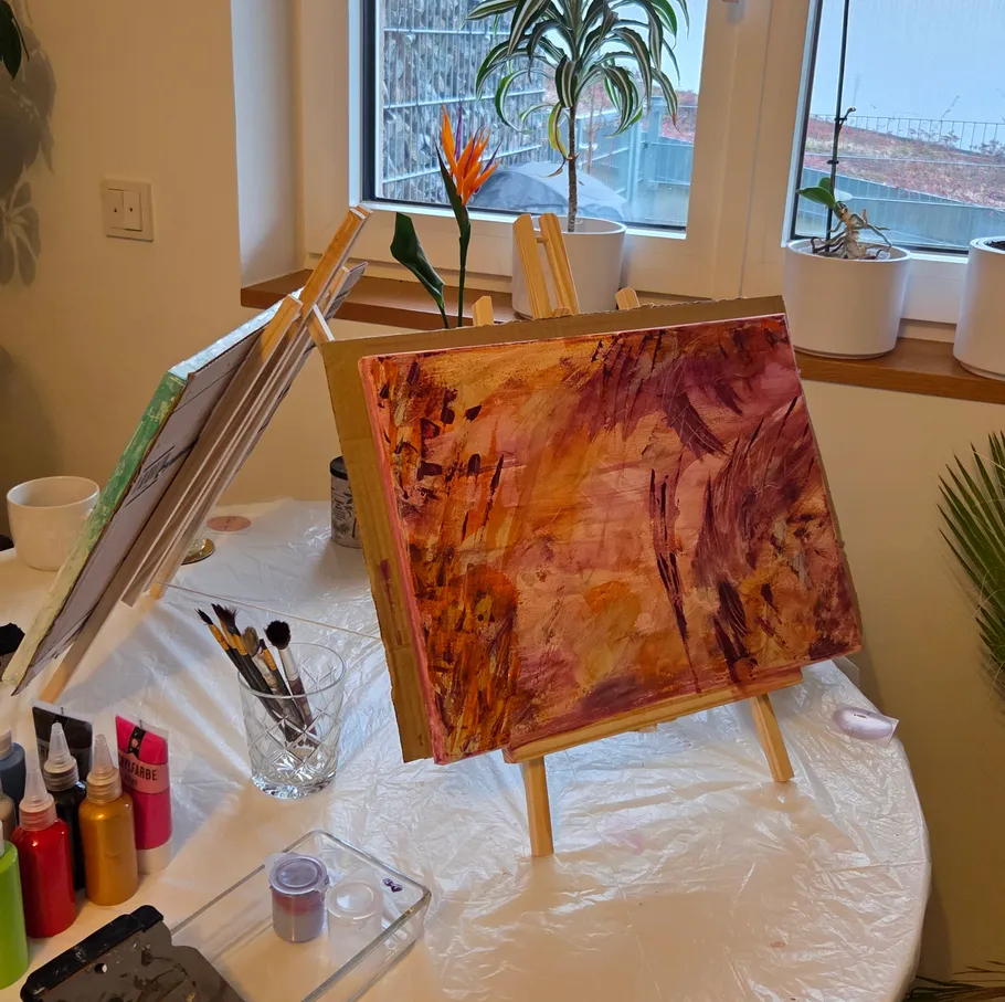 Abstract painting on easel in decorated room.