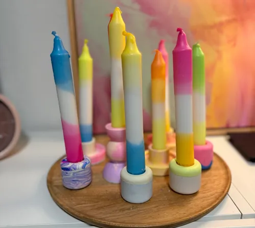 Colorful candles standing upright against painting.