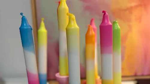 Colorful candles standing upright against painting.