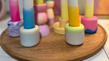 Bunte Holzspielzeuge auf einem runden Tablett.