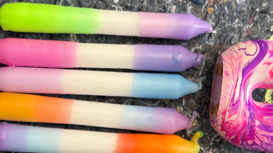 Colorful gradient candles on textured surface.