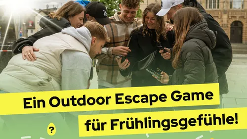Gruppe spielt mit Handys im Freien.
