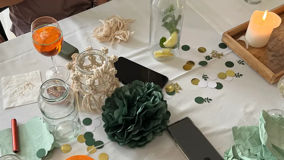 Table setup with drinks, decorations, and candle.