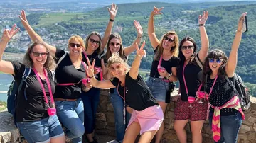 Group of women celebrating outdoors on a stone wall.