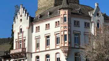 Historisches Gebäude mit dekorativer Fassade und Turm.