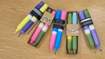 Colorful candles wrapped in paper on table.