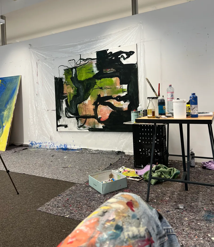Abstract painting in art studio with supplies.