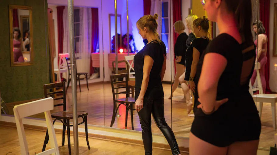 Frauen üben in einem Spiegel-Tanzstudio.